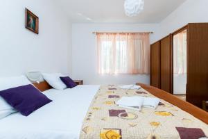 una camera da letto con un letto grande con asciugamani sopra di Apartments Luci a Rab