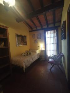 a bedroom with two beds and a window and a chair at Villetta Il Nespolo in Barberino di Mugello