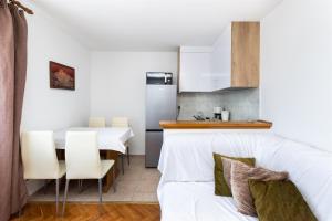 eine Küche und ein Wohnzimmer mit einem weißen Sofa in der Unterkunft Apartments Zdenka in Lopar