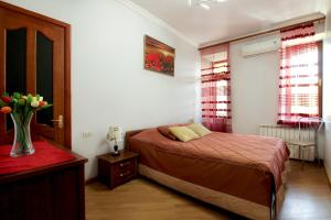 1 dormitorio con 1 cama y un jarrón de flores en 2 Bedroom Apartment on Tumanyan street en Ereván