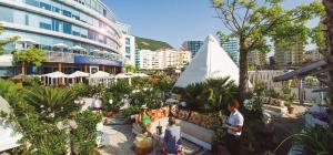 un groupe de personnes debout dans une cour d'une ville dans l'établissement Ocean Spa Plaza Resort Apartment, à Gibraltar