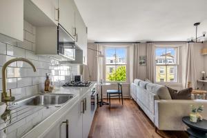 a kitchen and living room with a couch and a sink at Be London - The St John's Wood Residences in London