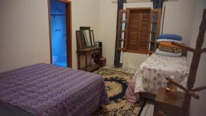 a bedroom with a bed and a window at MonteVerdeMG, Fibra Óptica, fácil acesso, térrea . in Monte Verde