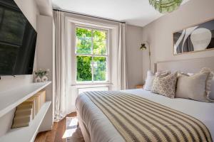 a white bedroom with a large bed and a window at Be London - The St John's Wood Residences in London