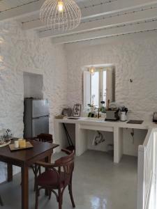 uma cozinha com uma secretária, uma mesa e cadeiras em Oniropagida Nisyros apartments #2 Nikia view em Nikiá