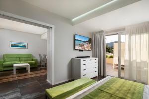 a bedroom with a green bed and a green couch at Hotel San Teodoro in San Teodoro
