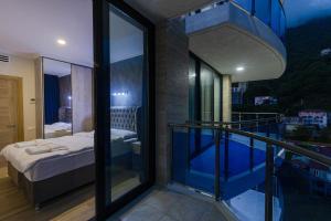 a room with a balcony with a bed and a bedroom at Kvariati Panorama in Kvariati +27 photos