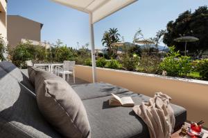 a room with a couch and a book on a balcony at Hotel San Teodoro in San Teodoro
