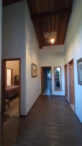 a living room with a ceiling fan and a hallway at MonteVerdeMG, Fibra Óptica, fácil acesso, térrea . in Monte Verde