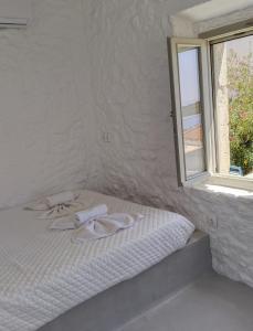 a white bed with towels on it next to a window at Oniropagida Nisyros apartments #2 Nikia view in Nikiá