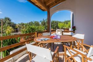 un patio esterno con tavolo e sedie in legno di Mare Relax a Lido Marini
