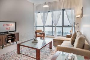 a living room with a couch and a tv at LOVELY 3 Bedroom Apartment Beach Front (City View) in Abu Dhabi
