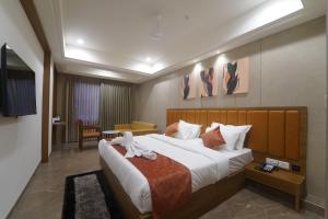 een hotelkamer met een groot bed met handdoeken erop bij HOTEL STATURE INN in Kevadia