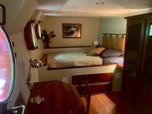 - une petite chambre avec un lit et un bureau dans l'établissement Péniche Odilia, à Avignon