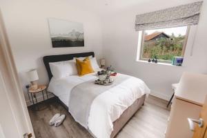 a bedroom with a bed and a window at Beautiful "Stour" Eco Lodge with Private Hot Tub in East Bergholt