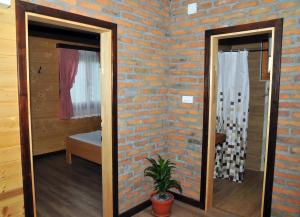 a room with a brick wall and two mirrors at Milošev vajat - Miloš's cottage in Mionica