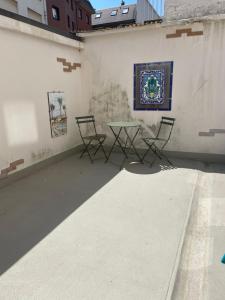 a patio with chairs and a table on a wall at Comfortabele, moderne studio zeedijk De Panne in De Panne