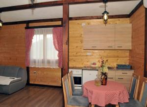 eine Küche und ein Esszimmer mit einem Tisch, einer Küche und einem Sofa in der Unterkunft Milošev vajat - Miloš's cottage in Mionica