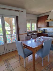 a kitchen with a wooden table and blue chairs at piso chalet en playa samil in Vigo