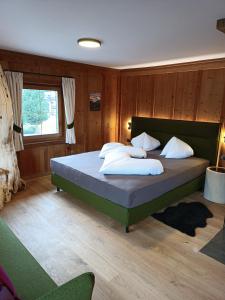 a bedroom with a large bed with wooden walls at Obersanterhof in Sesto