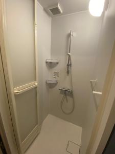 a white bathroom with a shower and a sink at ステイワーク錦糸町 in Tokyo