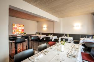 un comedor con mesas y sillas blancas en Prümer Gang Restaurant & Hotel, en Bad Neuenahr-Ahrweiler