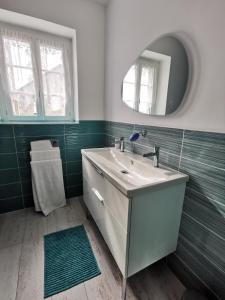 uma casa de banho com um lavatório e um espelho em Les 3 Cheminées em Granville