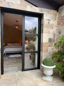 una puerta corredera de cristal que da a un patio con sofá en La chambre l'Eucalyptus en Saint-Laurent-du-Bois