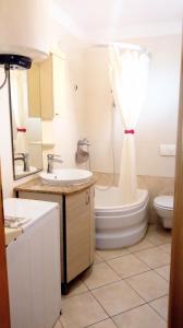 La salle de bains est pourvue d'un lavabo, de toilettes et d'un rideau de douche. dans l'établissement Grand Vista, à Tkon