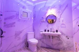 uma casa de banho com um WC, um lavatório e um espelho. em Joene Vintage Apartment em Tessalônica