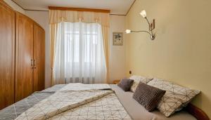 Schlafzimmer mit einem Bett und einem Fenster in der Unterkunft Apartment Alba in Brtonigla