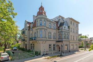 un grand bâtiment avec une tourelle dans une rue dans l'établissement Lion Apartments - Hampton Family Apartment with two bedrooms, à Sopot