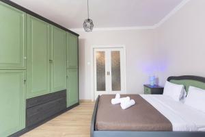 1 Schlafzimmer mit grünen Schränken und 1 Bett mit 2 Handtüchern in der Unterkunft Joene Vintage Apartment in Thessaloniki