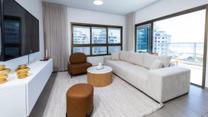 a living room with a couch and a tv at O&O Group - SeaFront Luxurious 3 BR Apartment in Bat Yam
