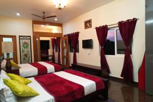 two beds in a room with red curtains at Forest View Resort in Yercaud