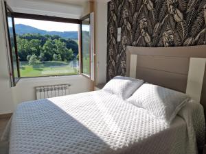 1 dormitorio con cama y ventana grande en Barquerina - Ría de Villaviciosa, en Villaviciosa