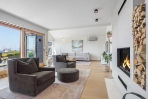 sala de estar con 2 sillas y chimenea en Exclusive Family Villa in Haugesund - Lovely Ocean View, 5 Bedroom, Free parking, en Haugesund