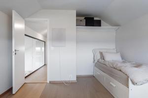 a white bedroom with a bed and a mirror at Exclusive Family Villa in Haugesund - Lovely Ocean View, 5 Bedroom, Free parking in Haugesund