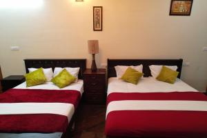 two beds sitting next to each other in a room at Forest View Resort in Yercaud