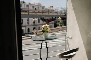 a table with a vase of flowers on a balcony at Le stanze del Piccadilly in Genoa