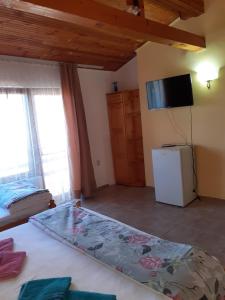 1 dormitorio con 1 cama y TV en la pared en Guest House Sun, en Kranevo