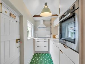 a kitchen with white cabinets and a green floor at Pass the Keys Stunning Georgian Cottage In The City in Canterbury