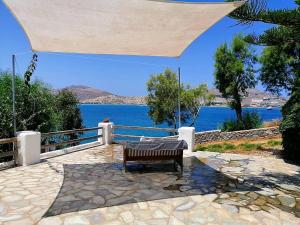 a bench sitting on a patio with a view of the water at Votsalo Apartments in Naousa