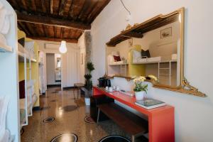 een kamer met een rood bureau en een spiegel bij Le stanze del Piccadilly in Genua