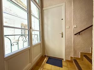 un pasillo vacío con una puerta y una ventana en Polichinelle *Central *Charmant *Calme en Pézenas