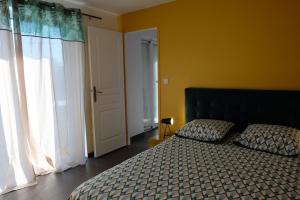 ein Schlafzimmer mit einem Bett und einem großen Fenster in der Unterkunft Le GITE DU VILLAGE in Franleu