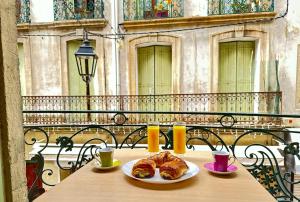 a table with two plates of croissants on it at Polichinelle Hyper Centre - Wifi - Balcon & Parking Proche in Pézenas