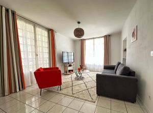 a living room with a couch and a red chair at Polichinelle Hyper Centre - Wifi - Balcon & Parking Proche in Pézenas