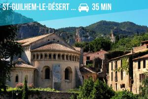 an old building with a mountain in the background at Polichinelle Hyper Centre - Wifi - Balcon & Parking Proche in Pézenas
