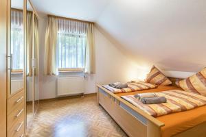 a bedroom with two beds and a large window at Ferienwohnung Haus am Wald in Meßstetten